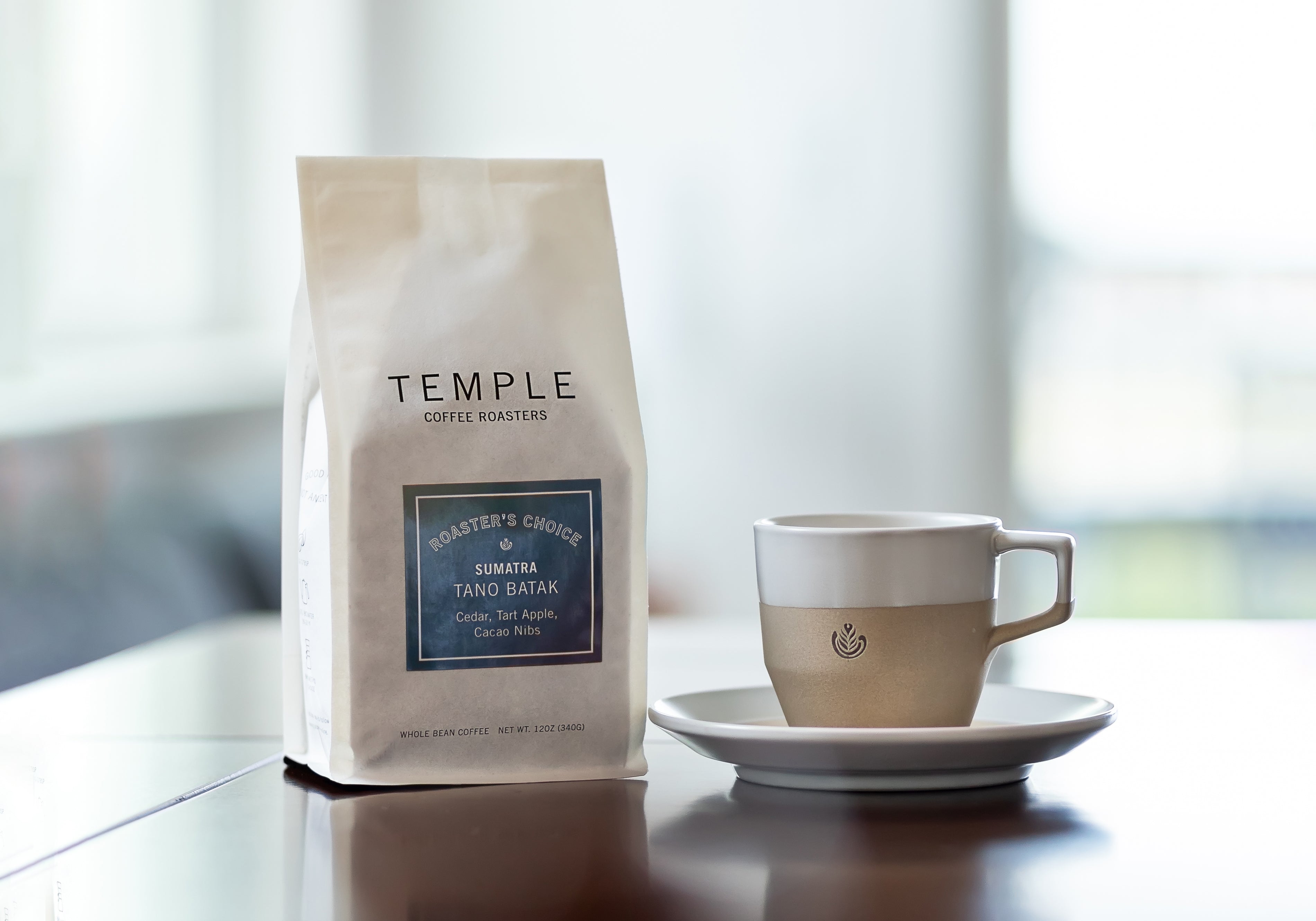 Coffee bag and mug with saucer on table.