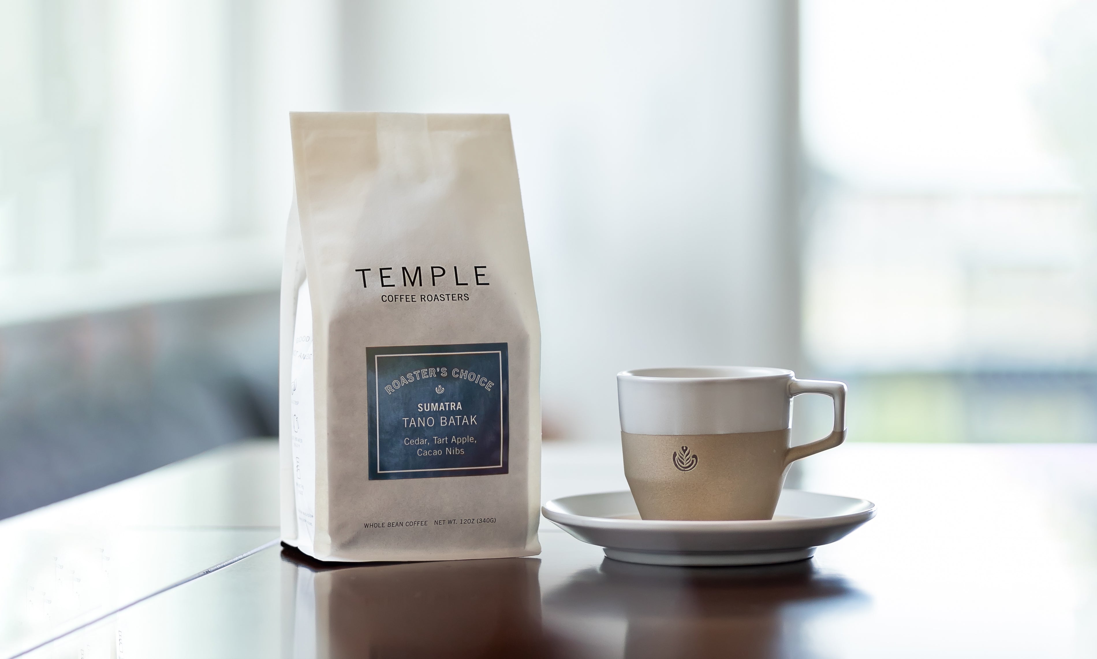 Coffee bag and mug with saucer on table.
