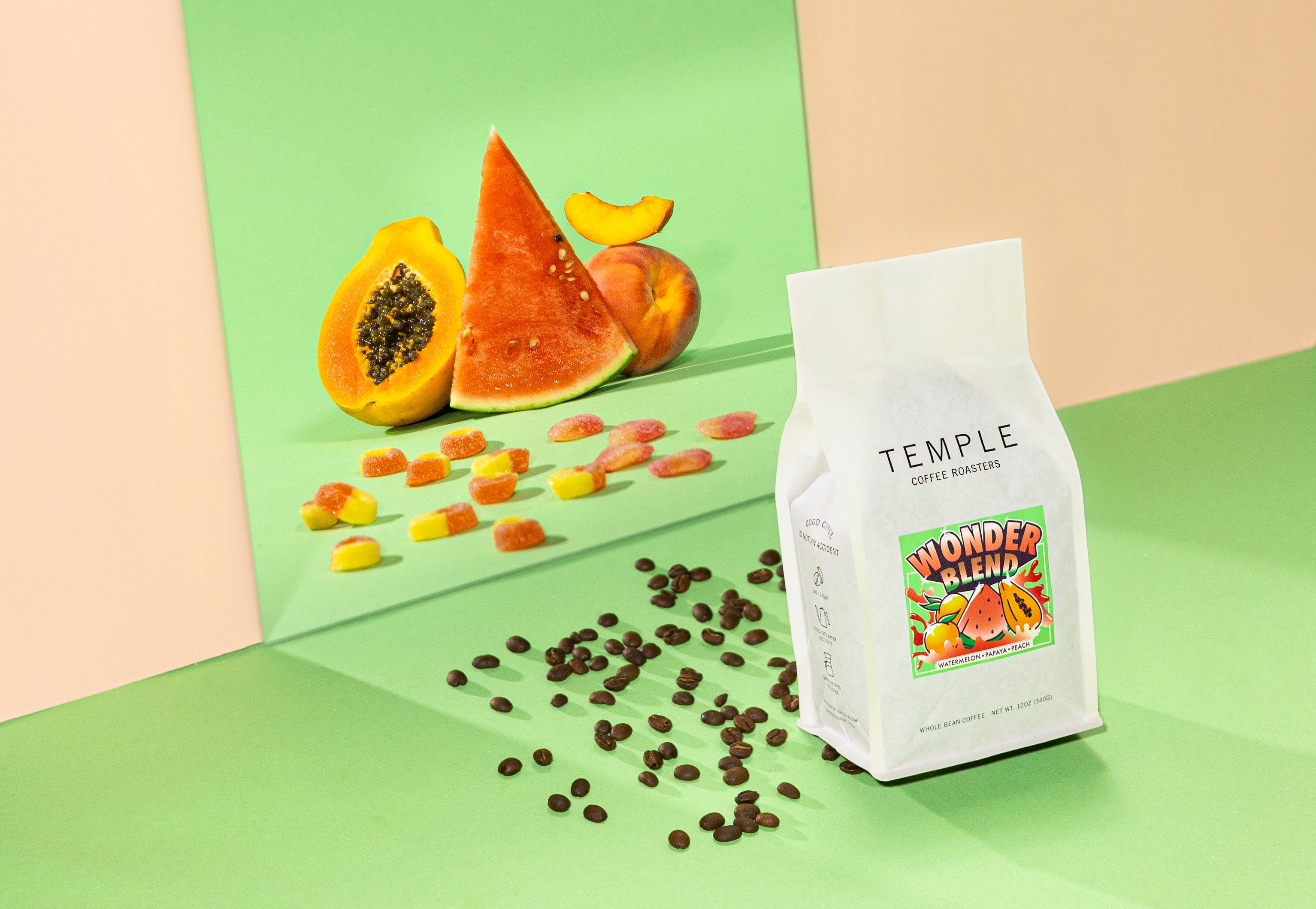 Bag of coffee with fruit reflected behind it in a mirror.