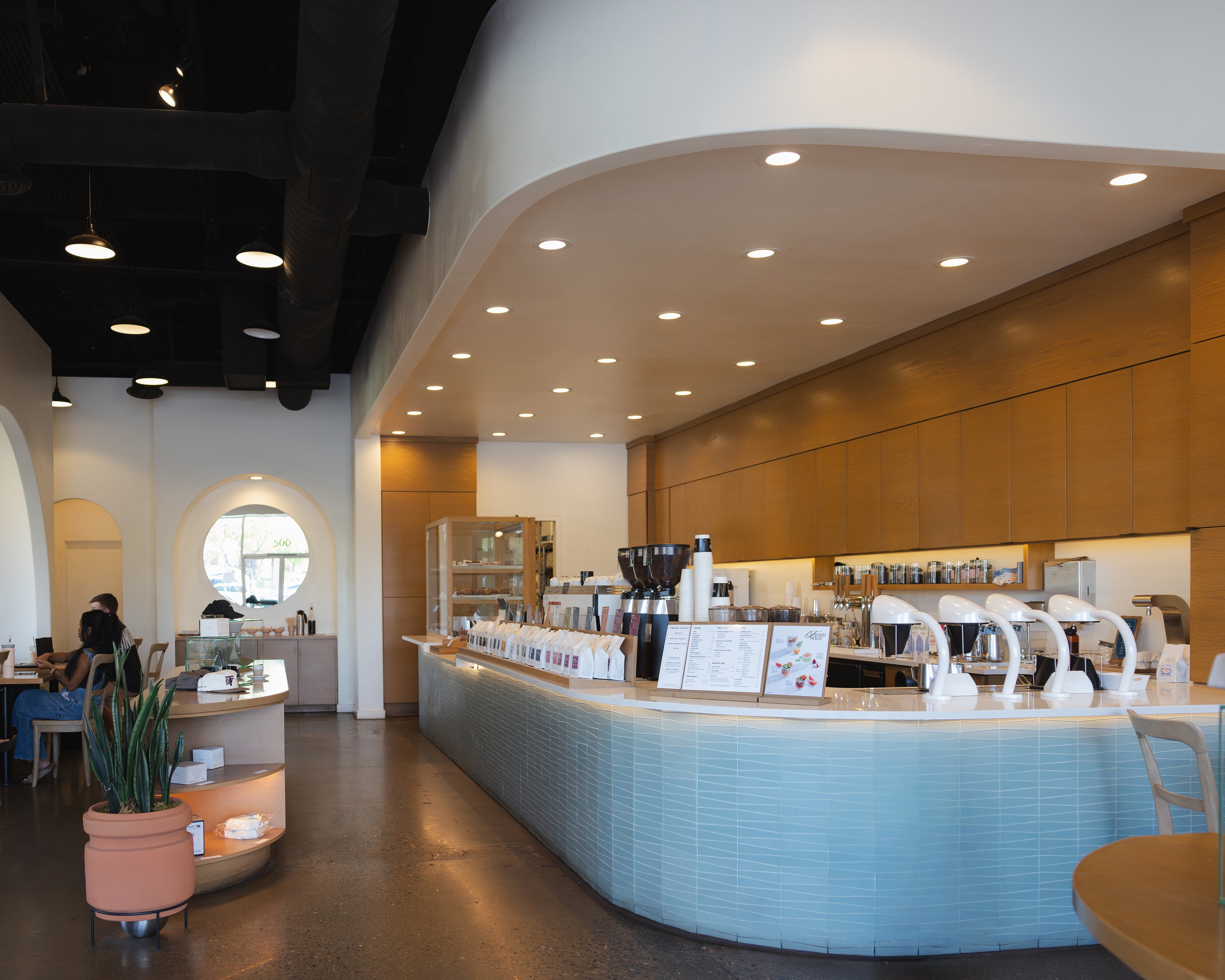 Modern interior of a coffee shop with a counter and seating area.