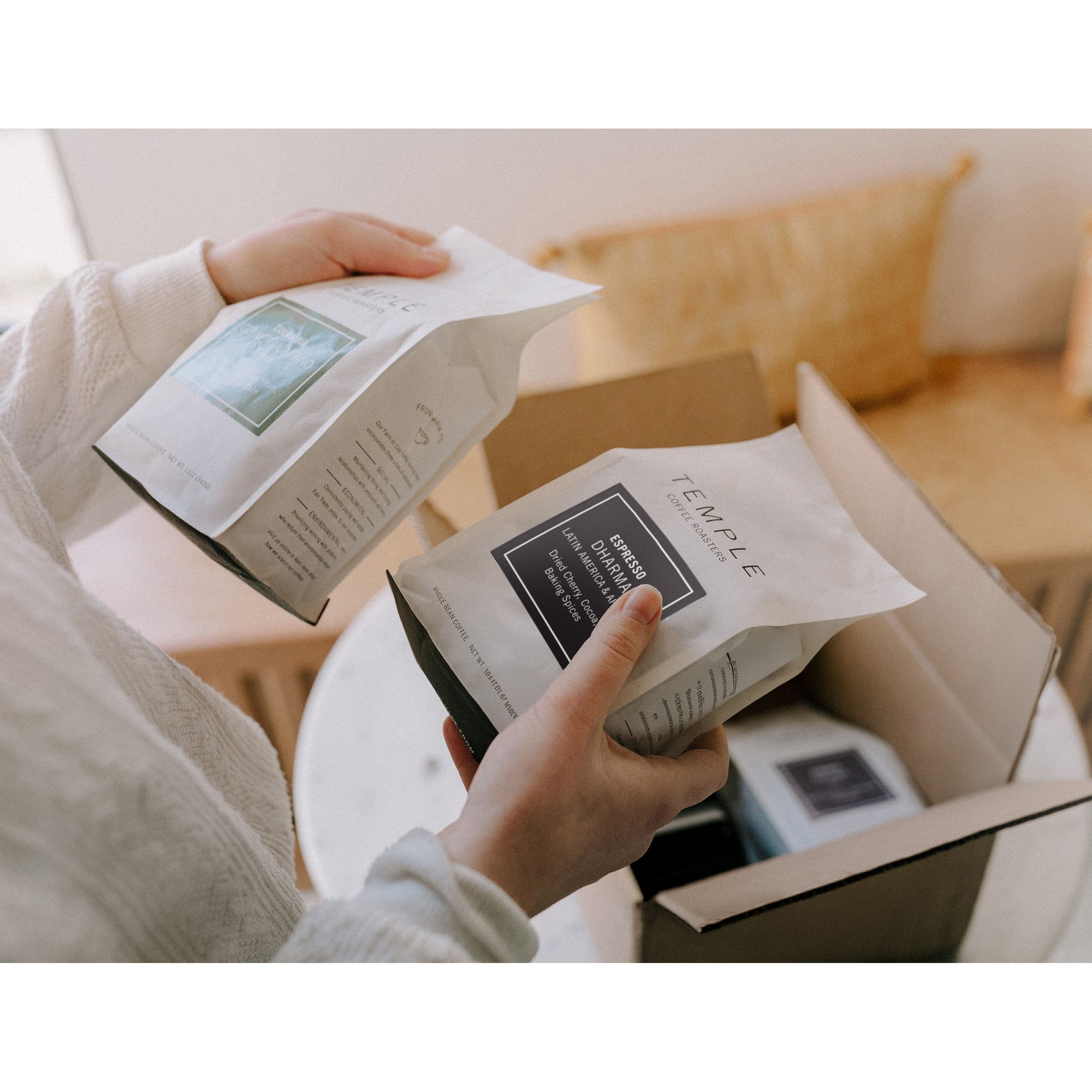 Person unpacking boxes with 'Temple' branding in a home setting.
