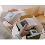 Person unpacking boxes with 'Temple' branding in a home setting.