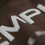Close-up of a brown fabric with white text on a dark background