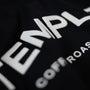Close-up of a black t-shirt with white text on a dark background