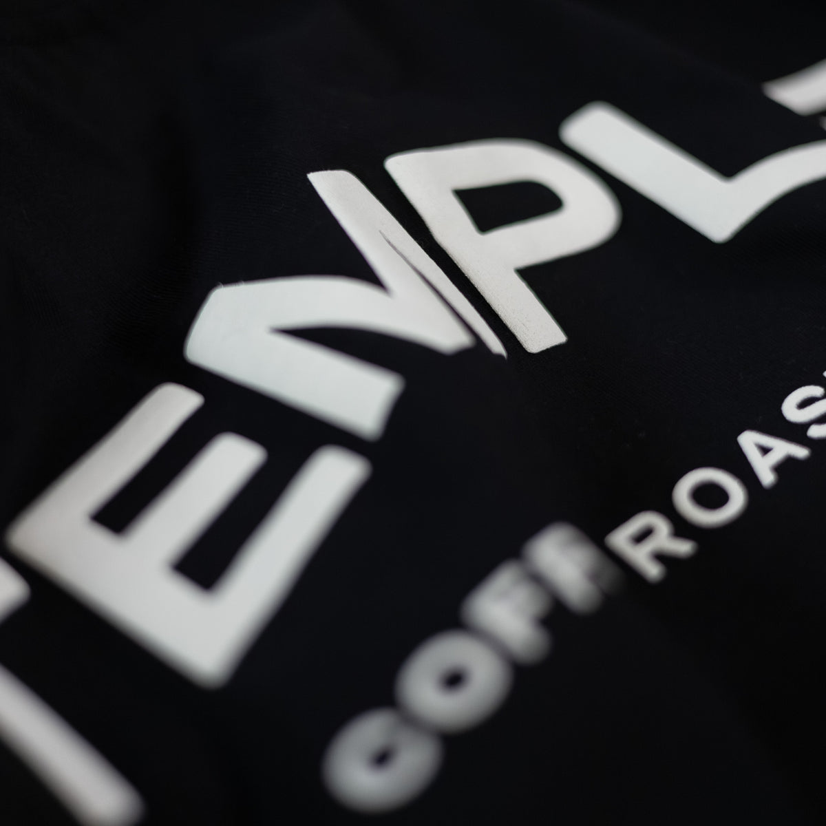 Close-up of a black t-shirt with white text on a dark background