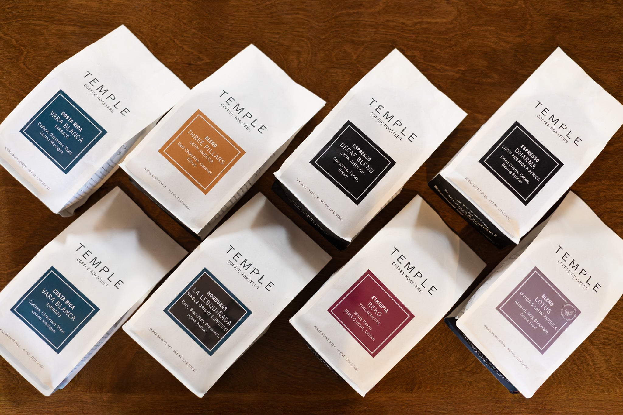Multiple bags of Temple coffee on a wooden surface