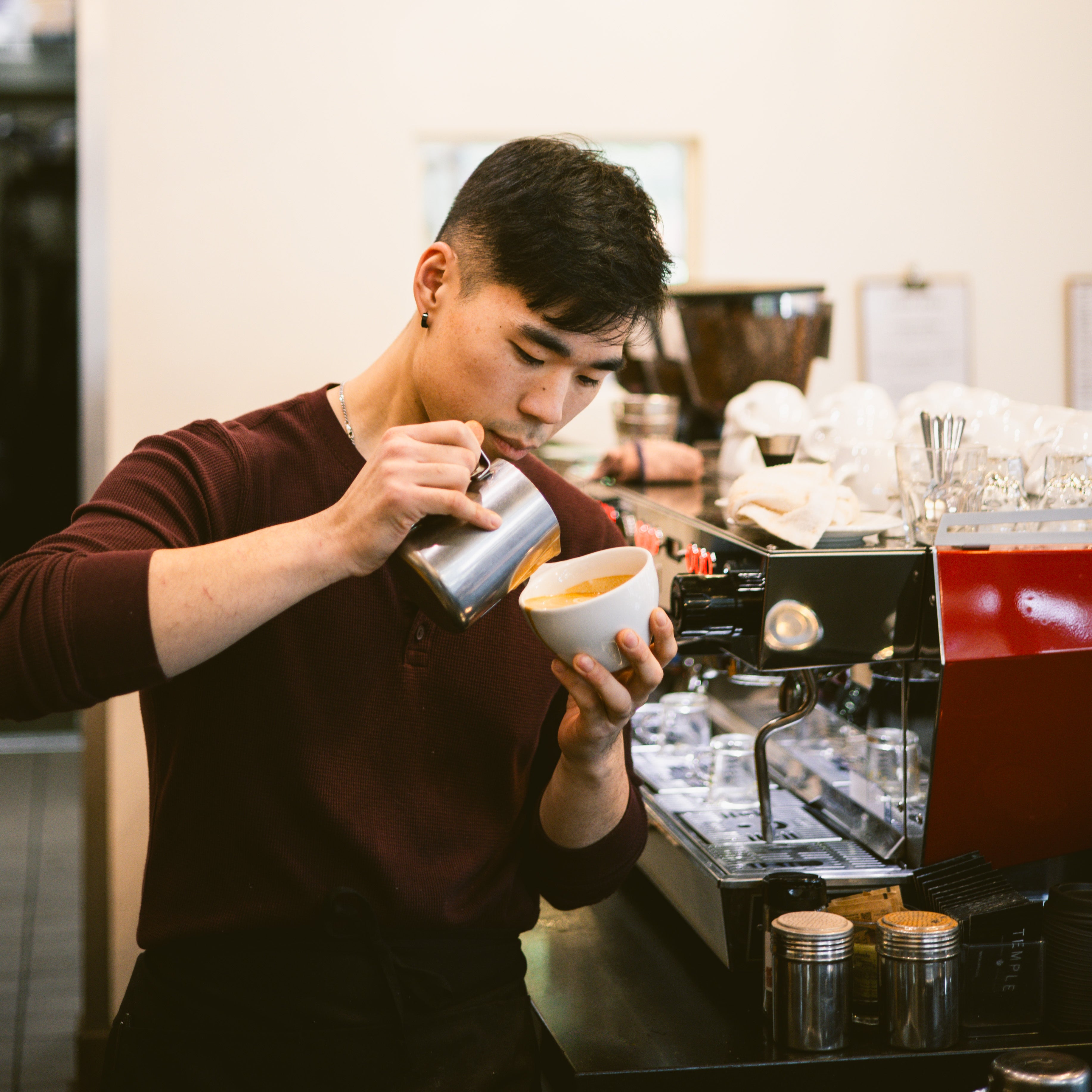 Barista preparing a coffee drink in a coffee shop.