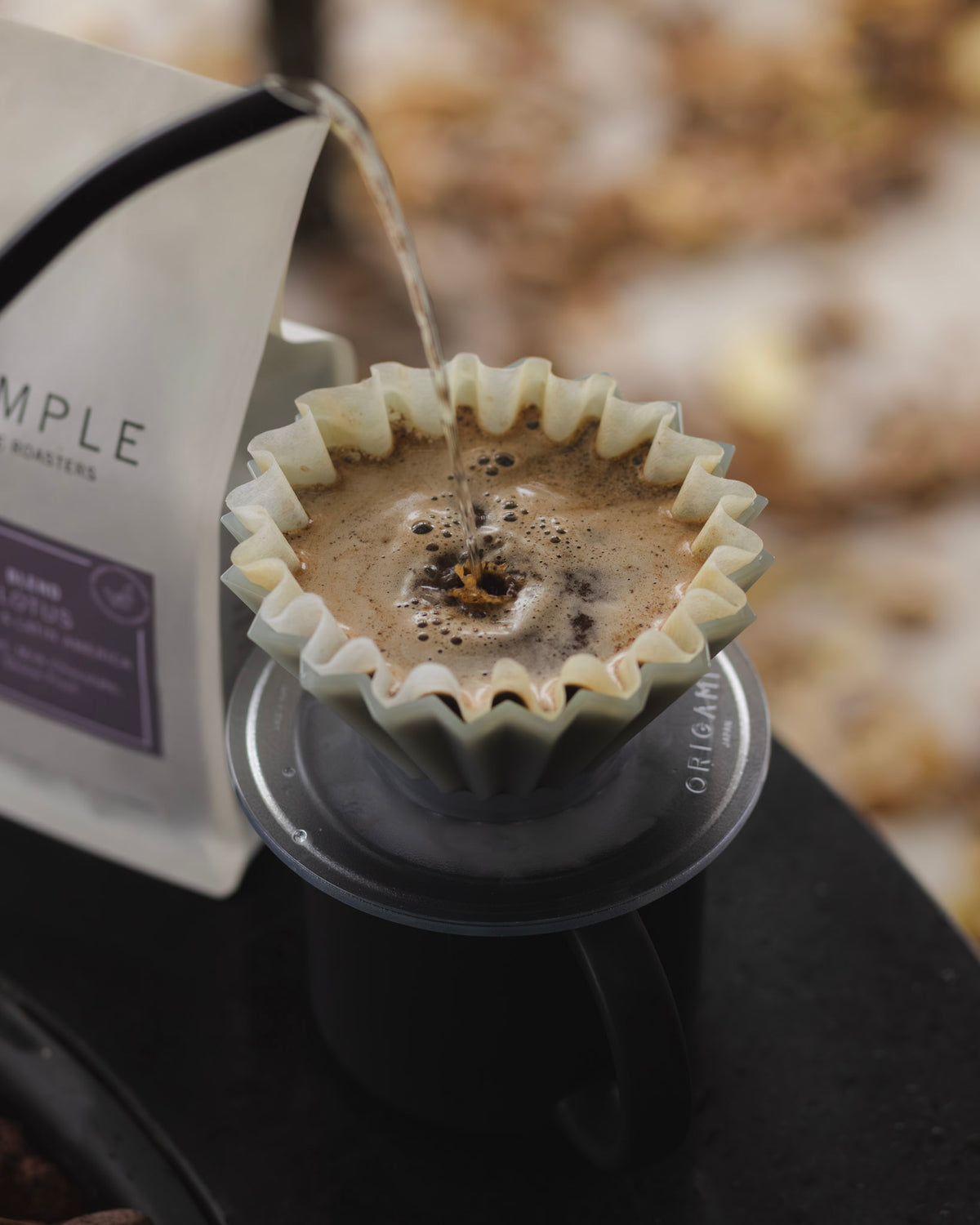 Coffee being poured into a Origami Dripper with a blurred background