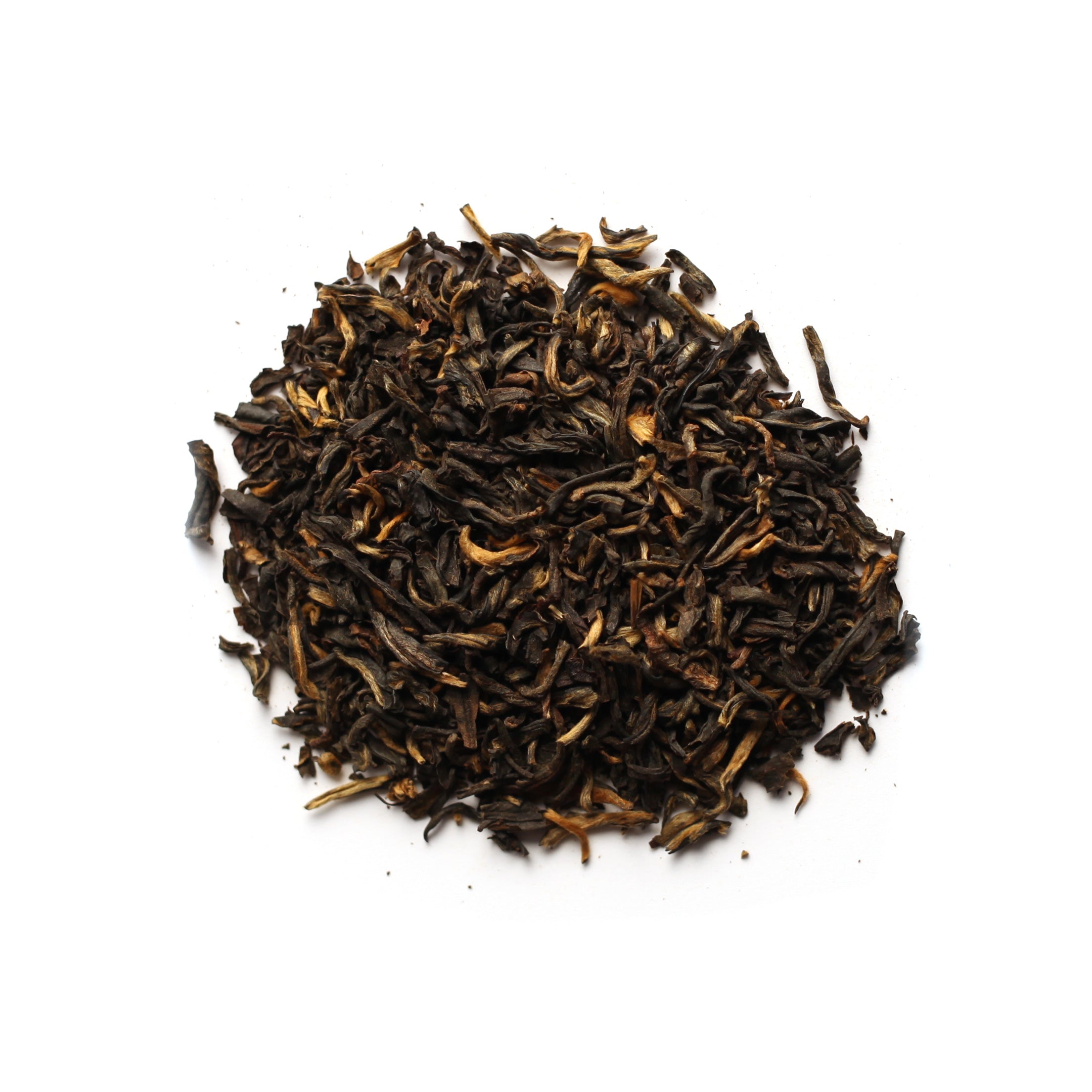 A pile of dry black tea leaves with some golden tips, on a white background.