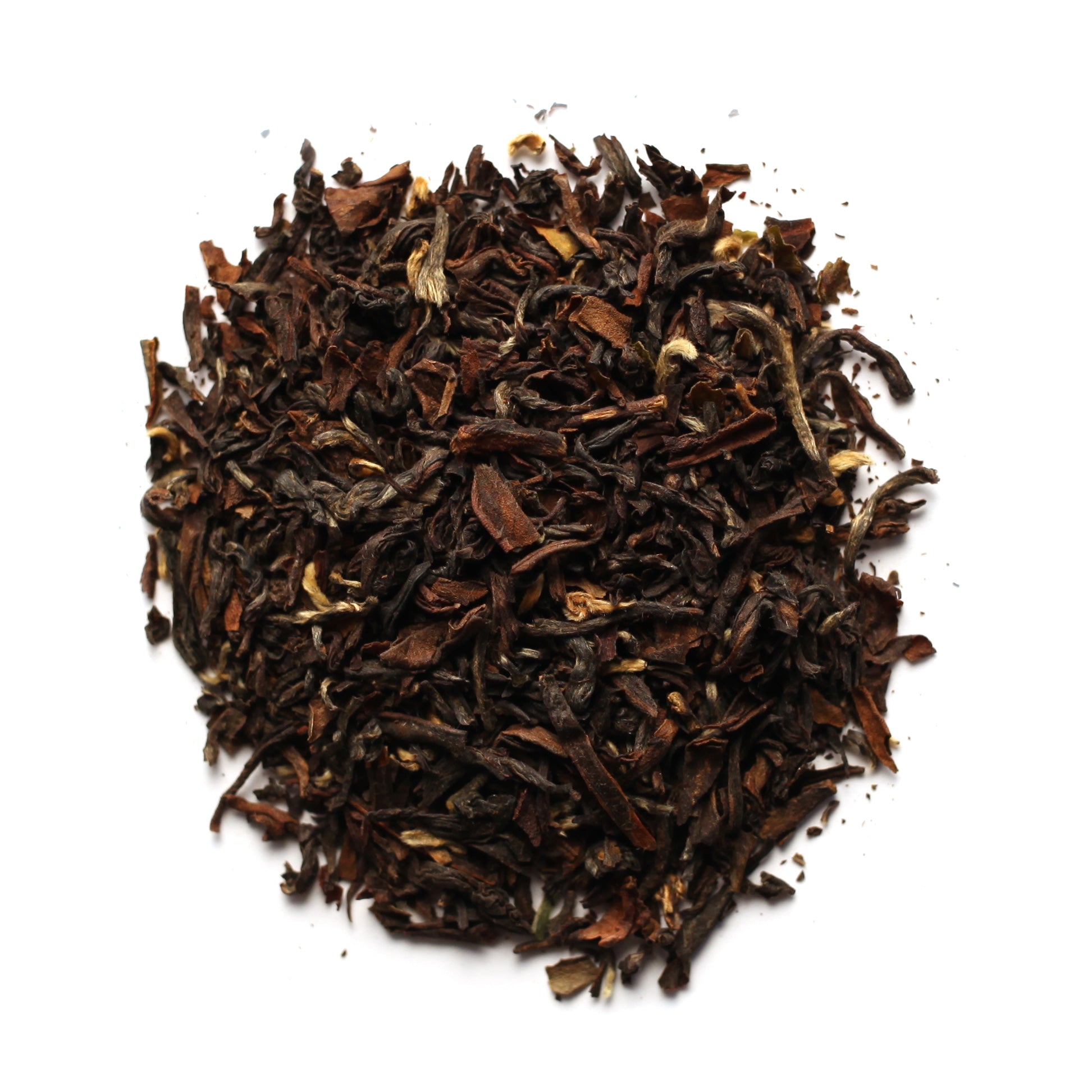 A pile of dry black tea leaves with some lighter, broken pieces visible on a white background.