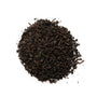A pile of black tea leaves with hints of orange zest, indicative of the Black Earl Grey tea blend.