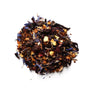 A close-up of a Rooibos herbal tea blend with visible pieces of orange peel, currants, rosehips, hibiscus, and cornflower petals.