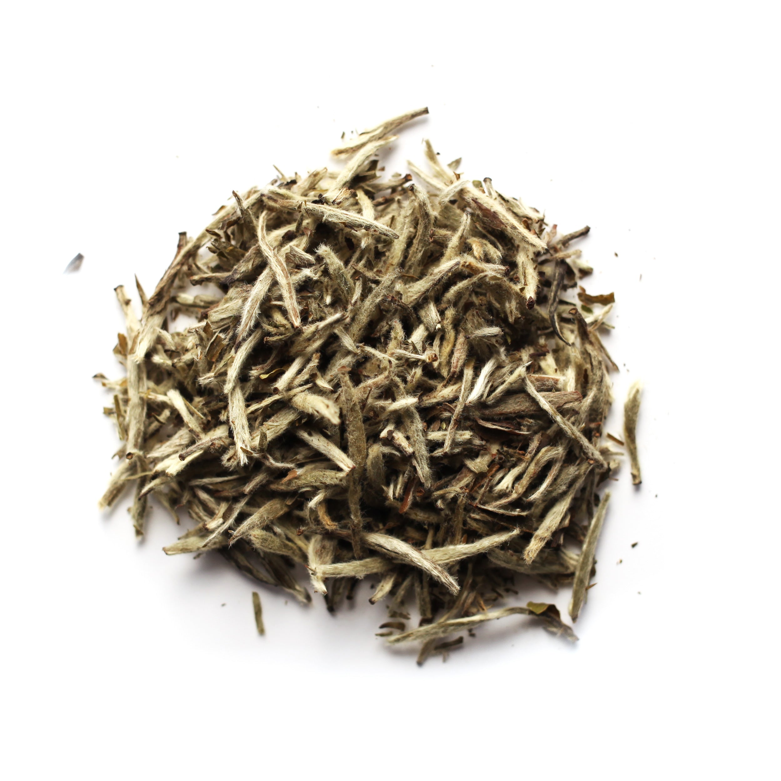 A pile of silver needle white tea buds against a white background.