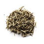 A pile of silver needle white tea buds against a white background.