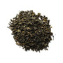A pile of dry, twisted green tea leaves.